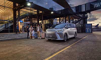 A family load their luggage into a Lexus LM at the airport arrivals zone