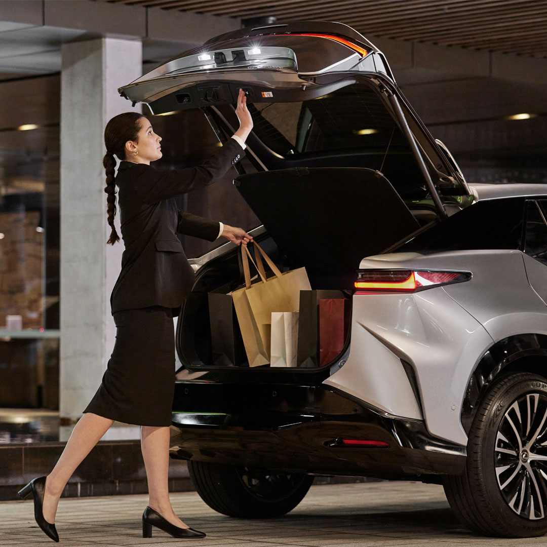 Valet promotion provided by Lexus Encore lifestyle benefits shows a woman placing shopping bags in the boot of a Lexus vehicle.